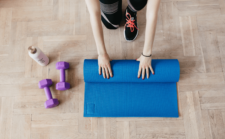 Rolling up a yoga mat on luxury vinyl flooring